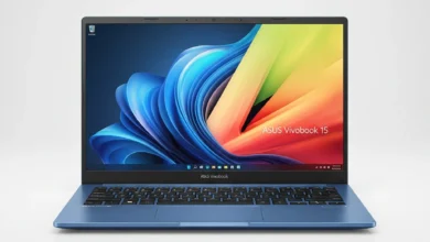 Asus Vivobook 15: Esta é uma imagem de estúdio, com estilo profissional. O notebook ASUS Vivobook 15 azul está aberto e posicionado de frente, centralizado sobre um fundo branco e minimalista. A iluminação é suave e uniforme, realçando o design elegante, a cor vibrante do aparelho e a sua tela ligada, que exibe um papel de parede colorido. A imagem transmite uma sensação de modernidade e sofisticação.