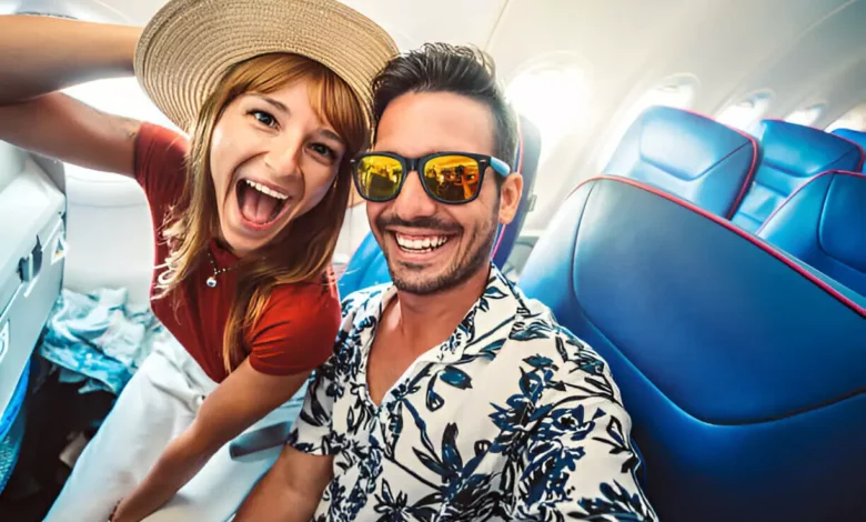 Pacotes e Dicas para o Feriado de Páscoa: Casal sorridente tirando selfie dentro de um avião, pronto para viajar no feriado. Crédito: iStock.