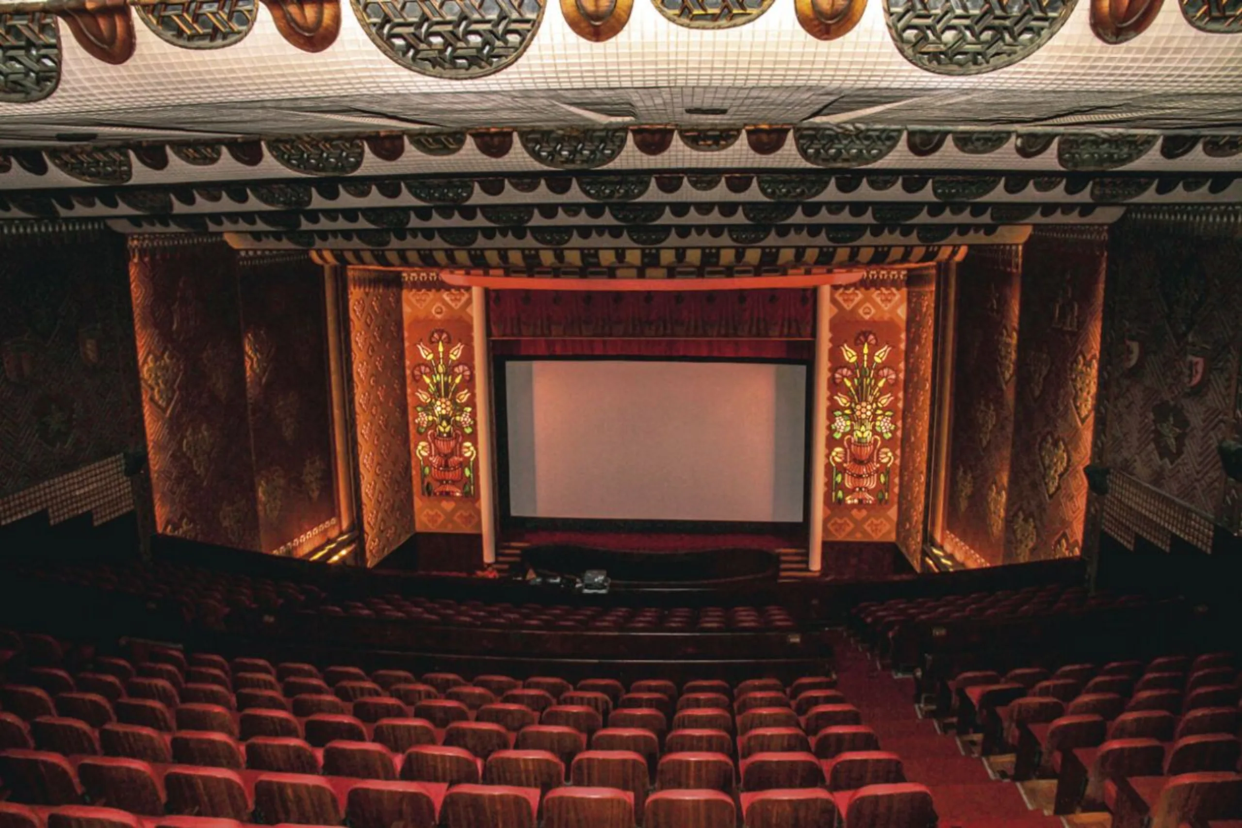Interior do Cinema São Luiz em Recife, com plateia, palco e arquitetura histórica.