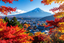 Monte Fuji ao fundo com vila japonesa e árvores em tons de vermelho e laranja durante o outono.