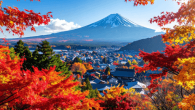 Monte Fuji ao fundo com vila japonesa e árvores em tons de vermelho e laranja durante o outono.