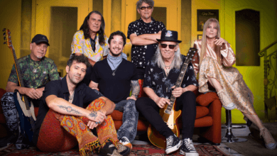 Integrantes da banda Tutti Frutti posam juntos em estúdio, alguns sentados e outros em pé, com instrumentos musicais.