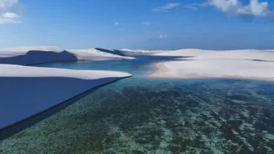 Lagoa de águas cristalinas entre dunas de areia branca nos Lençóis Maranhenses