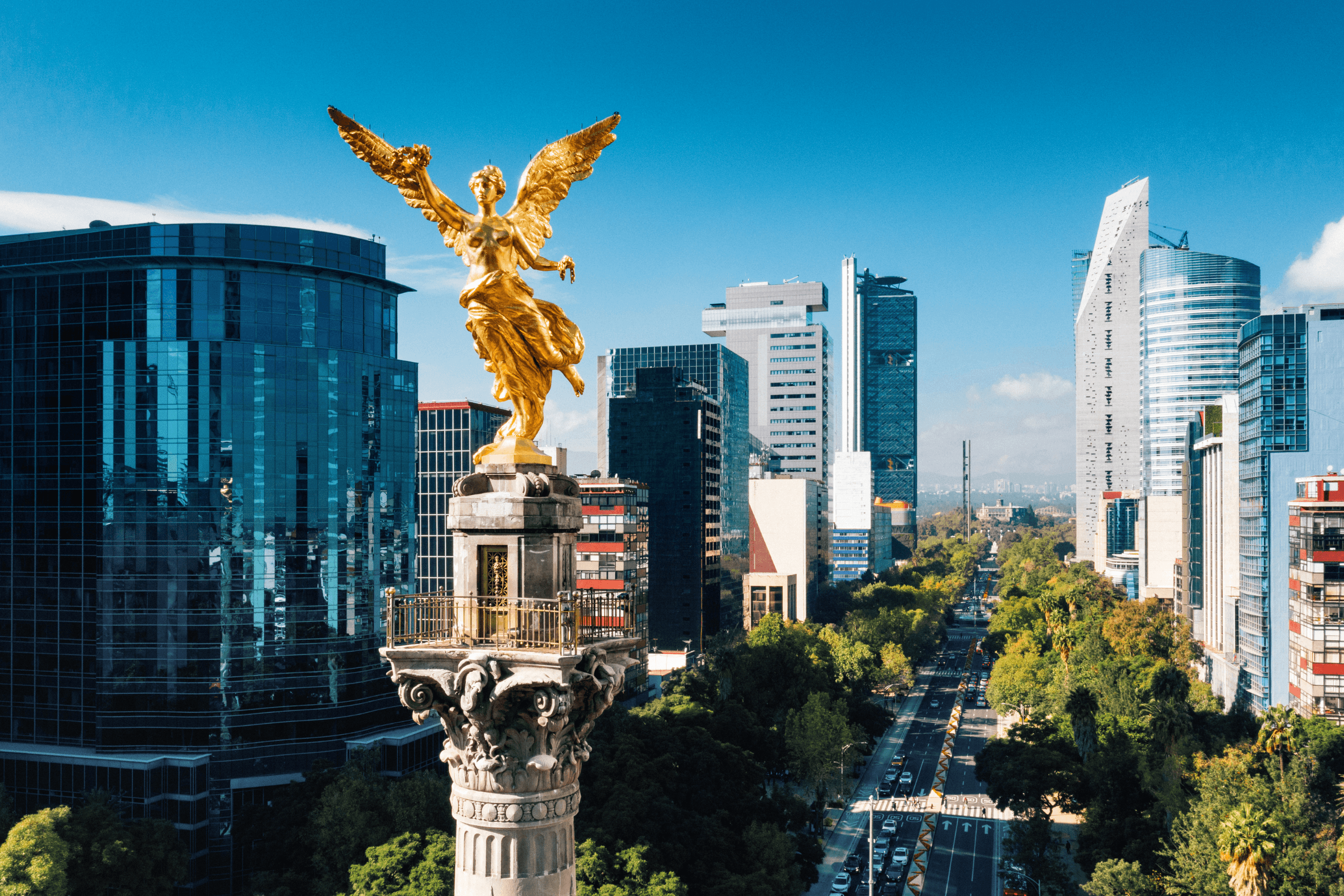 Estátua dourada do Anjo da Independência em destaque com prédios modernos ao fundo na Cidade do México.