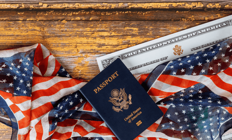 Close em visto americano estampado no passaporte com bandeira dos Estados Unidos ao fundo.