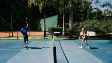 Dois jogadores praticando pickleball em quadra do Rituaali Clínica & Spa rodeada por palmeiras e vegetação tropical