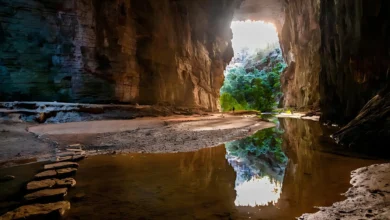 Interior da Gruta do Janelão no Peruaçu com abertura em arco iluminada pela luz natural refletida em lago interno