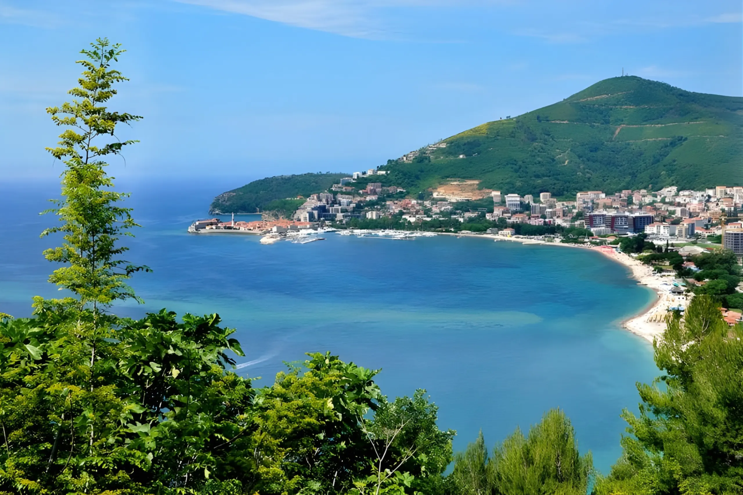 Vista aérea da baía de Montenegro com cidade histórica à beira-mar, montanhas verdes ao fundo e águas turquesa do mar Adriático