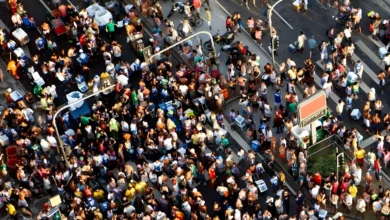 Vista aérea de multidão colorida em rua durante o Carnaval brasileiro com vendedores ambulantes e foliões