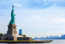 Estátua da Liberdade em Nova York com skyline de Manhattan ao fundo, símbolo da entrada nos Estados Unidos da América