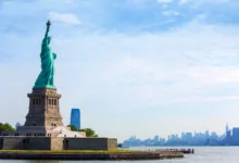 Estátua da Liberdade em Nova York com skyline de Manhattan ao fundo, símbolo da entrada nos Estados Unidos da América
