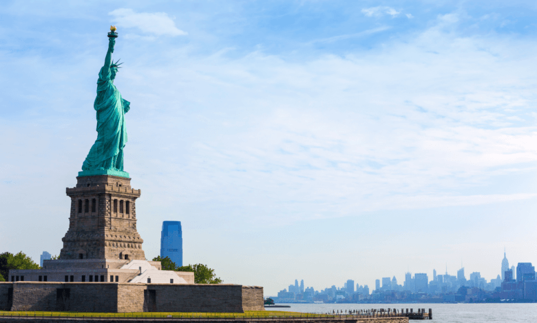 Estátua da Liberdade em Nova York com skyline de Manhattan ao fundo, símbolo da entrada nos Estados Unidos da América
