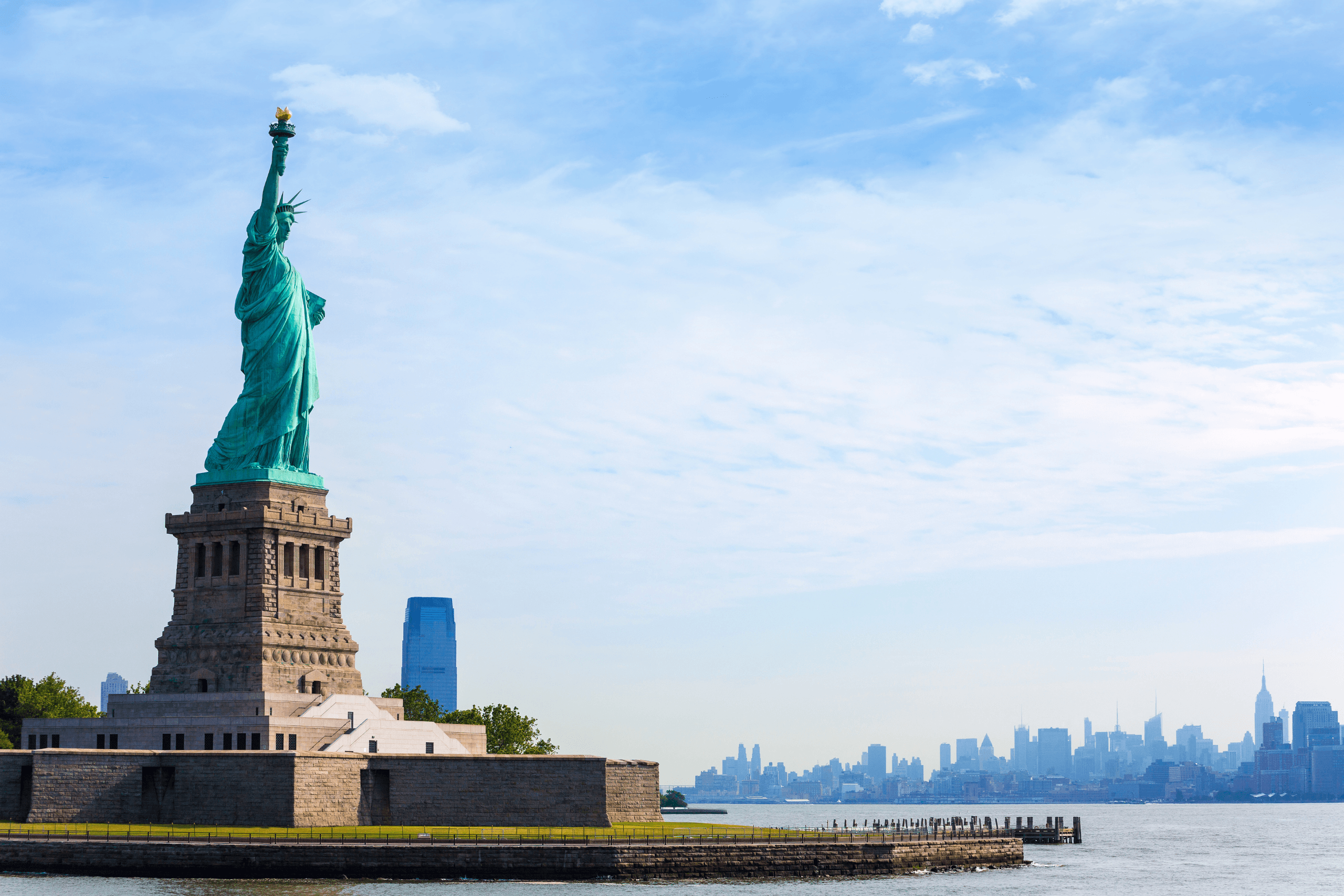 Estátua da Liberdade em Nova York com skyline de Manhattan ao fundo, símbolo da entrada nos Estados Unidos da América