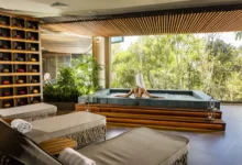 Área de hidroterapia do spa do Bendito Cacao Resort e Spa com mulher relaxando em banheira com vista para vegetação da Serra da Mantiqueira