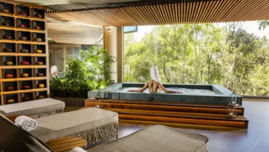 Área de hidroterapia do spa do Bendito Cacao Resort e Spa com mulher relaxando em banheira com vista para vegetação da Serra da Mantiqueira