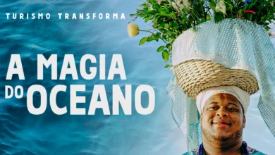 Homem negro com trajes afro-brasileiros em azul e branco ao lado do texto "A Magia do Oceano" — série Turismo Transforma da Embratur
