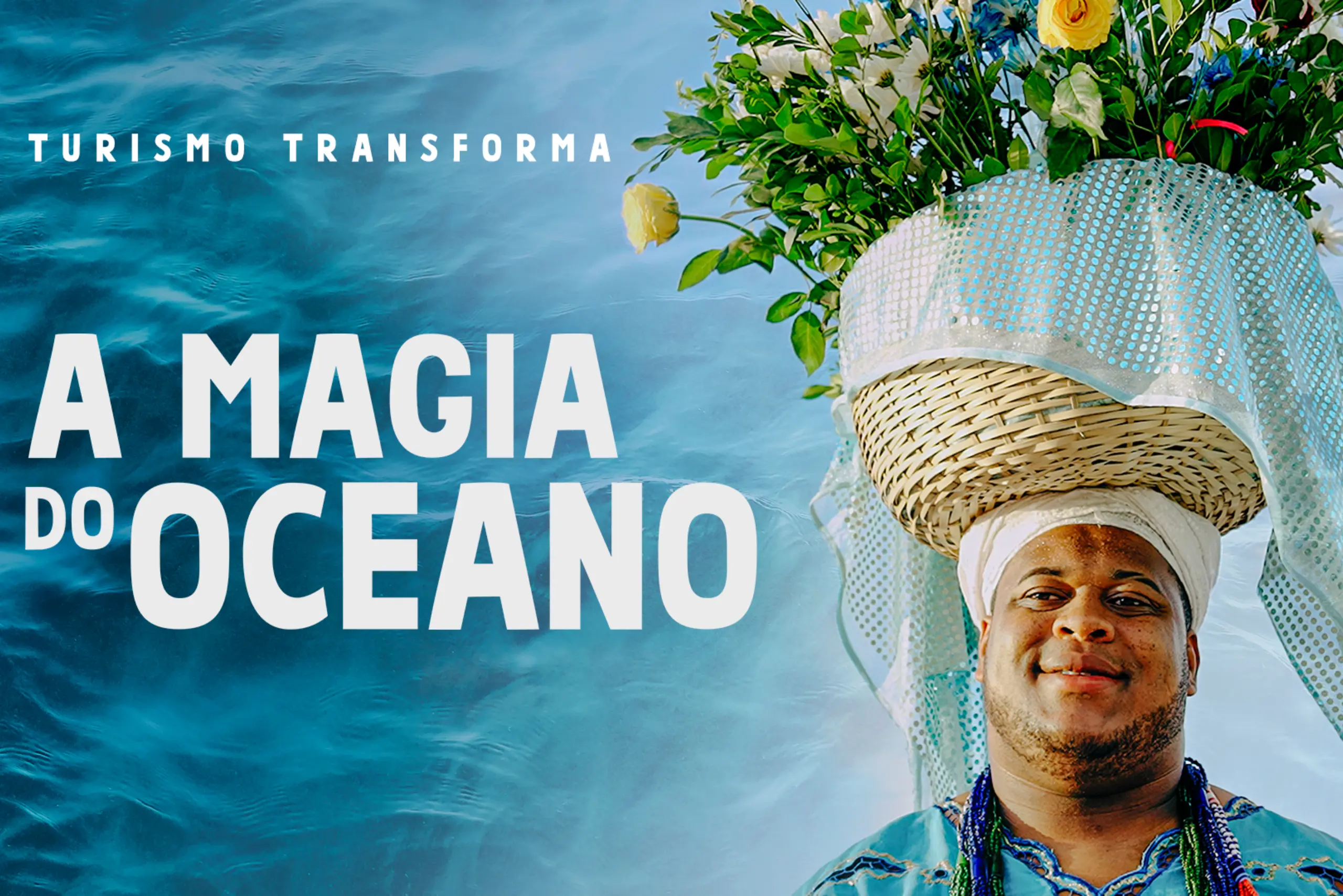 Homem negro com trajes afro-brasileiros em azul e branco ao lado do texto "A Magia do Oceano" — série Turismo Transforma da Embratur