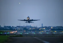 Avião decolando à noite com luzes de pista ao fundo representando voos suspensos para o Oriente Médio em 2026