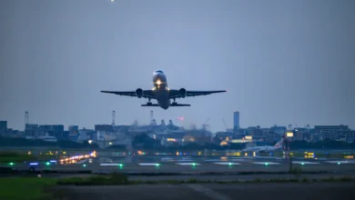 Avião decolando à noite com luzes de pista ao fundo representando voos suspensos para o Oriente Médio em 2026