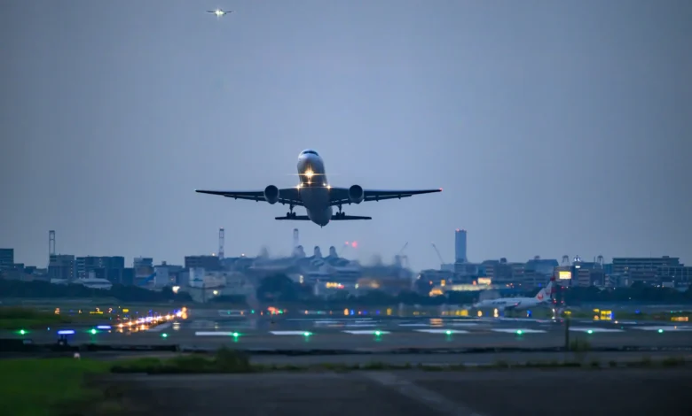 Avião decolando à noite com luzes de pista ao fundo representando voos suspensos para o Oriente Médio em 2026