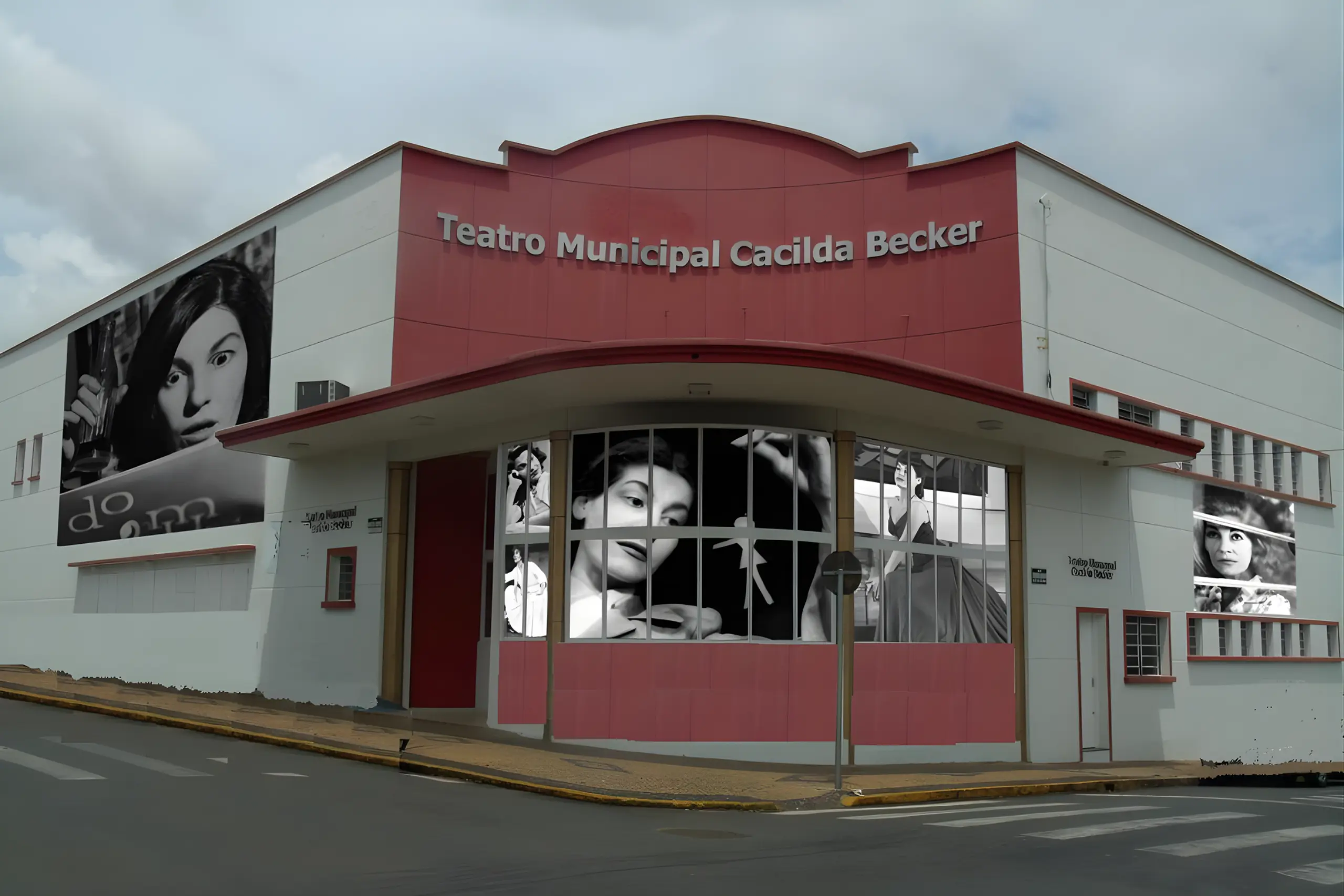 Fachada de um prédio de esquina branco e vermelho com a inscrição "Teatro Municipal Cacilda Becker". Janelas de vidro exibem painéis em preto e branco com o rosto da atriz Cacilda Becker.